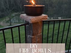 a fire bowl sitting on top of a wooden table next to a metal railing with the words diy fire bowls over it