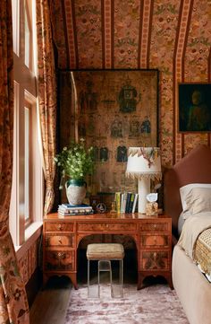 a bed room with a neatly made bed and a desk in front of a window