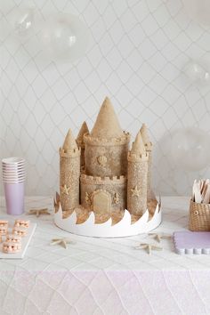 a castle made out of sand sitting on top of a table next to other items