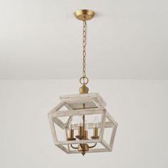 a chandelier hanging from the ceiling with four candles in it and one light on each side