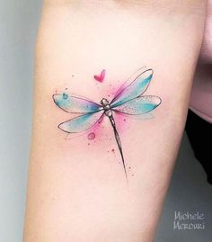 a watercolor tattoo with a dragonfly on the left side of the arm,