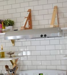 a stove top oven sitting inside of a kitchen next to a wall mounted pot rack