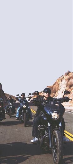 a group of people riding motorcycles down a road