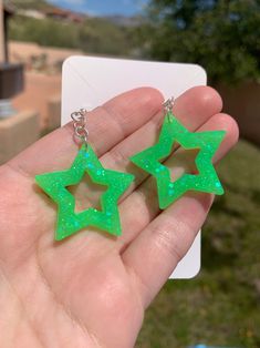 Each pair of neon green glitter star earrings are handmade to order, therefore no two pairs are identical! However, I try to get as close as possible :) Made with sterling silver fishhooks (clear rubber backing included). Hypoallergenic & nickel-free. Each star is approximately 30mm in length, and are made with resin, neon green glow in the dark powder pigment and neon green iridescent glitter. These handmade chunky neon green star earrings are glow in the dark and are uv blacklight reactive! Pe Cheap Green Star Shaped Earrings, Cute Green Jewelry For Party, Green Star-shaped Party Jewelry, Green Luminous Jewelry For Party, Luminous Green Jewelry For Party, Green Glitter Earrings As A Gift, Green Star-shaped Handmade Jewelry, Handmade Green Star-shaped Jewelry, Rave Jewelry