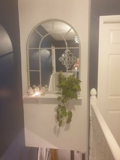 a plant is growing out of the window sill in front of a white door