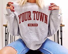 Customize your city and state on this comfy sweatshirt! The collegiate text can also be personalized to display your university crewneck sweater. FREE SHIPPING All items are made to order and there are no returns on merchandise. Please be sure to double check your order before placement, and see sizing chart and size recommendations to find the best fit for you! Ideal for any situation, this UNISEX heavy blend crewneck sweatshirt is pure comfort. These garments are made from polyester and cotton Funny Graduation Shirts, Senior Sweatshirts, Homebody Shirt, City Sweatshirt, Team Edward, Forks Washington, Retro Sweatshirts, Graduation Shirts, Up Book