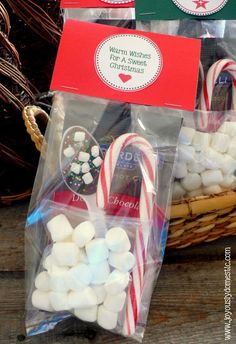 two bags filled with marshmallows next to a basket full of candy canes