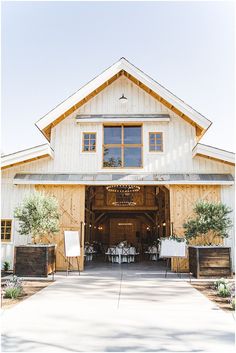 a barn with tables and chairs in front of it