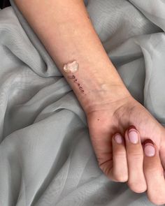 a woman's arm with a small tattoo on it that says i love you