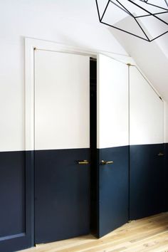 an empty room with two blue and white doors on the wall next to a wooden floor