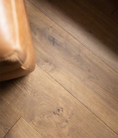 a brown leather chair sitting on top of a wooden floor