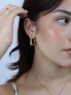 Step up your style game with these unique, geometric Gia Squared Hoops! Let these timeless, retro-inspired earrings give a bold touch to your wardrobe and make a statement with their one-of-a-kind design. Ready to take your look to the next level? Try them on and see the difference they make! Details: Size: 25mm x 20mm Tarnish-resistant, waterproof, and safe for sensitive skin Rectangular Earrings For Formal Occasions, Modern Yellow Gold Hoop Earrings, Chic Rectangular Earrings As Gift, Chic Rectangular Earrings For Everyday, Chic Rectangular Earrings For Gift, Trendy Bold Design Earrings, Modern Drop Plug Earrings, Chic Rectangular Everyday Earrings, Chic Everyday Rectangular Earrings