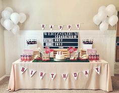 a birthday party with cake and decorations on the table in front of a large sign