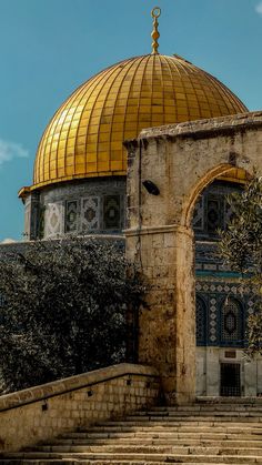 an old building with steps leading up to it and a golden dome on the top