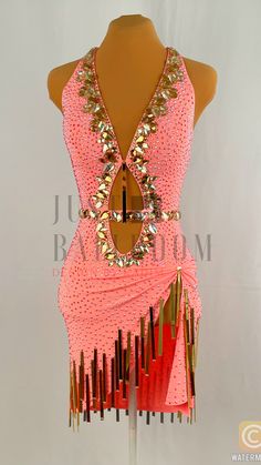 a mannequin wearing a pink dress with gold fringes on it's chest