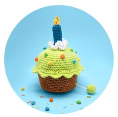 a crocheted cupcake with a candle on top