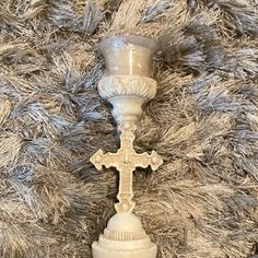 a white candle holder with a cross on it