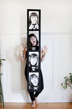 a woman standing in front of a wall with pictures on it's face and arms