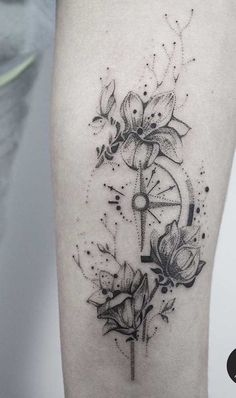 a woman's thigh with flowers and a clock tattoo on her left calf leg