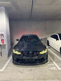 two cars parked in a parking garage next to each other on the same side of the street