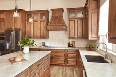 a kitchen with wooden cabinets and marble counter tops