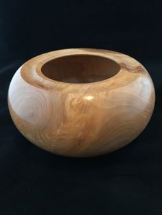 a wooden bowl sitting on top of a black table