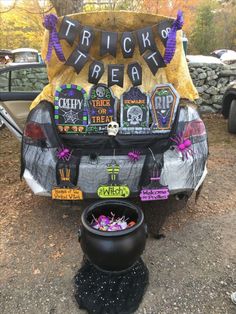 a car decorated for halloween with decorations on the trunk and tailgates that say trick or treat