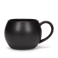 a black coffee cup sitting on top of a white table