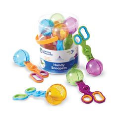 a bucket filled with lots of colorful plastic scissors and other toy items next to each other