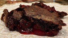 a close up of a piece of cake on a plate with cherries in it