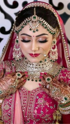 a woman wearing a pink and gold bridal outfit