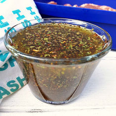 a glass bowl filled with food sitting on top of a table next to a blue container