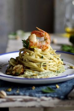 a white plate topped with pasta and shrimp