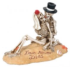 a skeleton figurine sitting on top of a rock