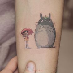 a person holding an umbrella next to a cartoon character on their arm with the image of a cat