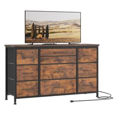 a flat screen tv sitting on top of a wooden dresser next to a metal frame