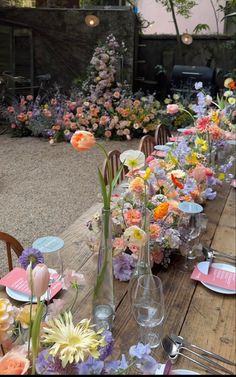 a long table is set with flowers and place settings for an outdoor dinner or brunch