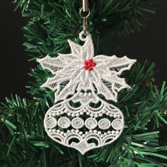 a white ornament hanging from a christmas tree