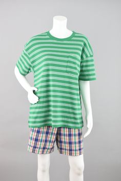 Vintage short sleeve loose fit jersey knit t-shirt in a soft blend of polyester and cotton. The color is in a lovely shade of green along with white stripes. Round crew neckline and one chest pocket. The hemline is slit on each side of the hips. Super cute casual shirt, fresh for Spring or Fall! Label Karen Scott // 80s - 90s era Condition Great condition No rips, tears or stains  Light piling all over from wear Machine washed, line dried & ready to wear Smoke free home Size Women's Large Norma Jean our model wears a size 5 in women's clothing.  I am a size 14/16 and weigh 175 pounds, this top fits me well.  Measurements Shoulder to shoulder - 24" Sleeve - 08" Bust/Waist/Hips - 46" Length - 26" Materials Polyester, Cotton ♡ Tid Bit More Info ♡ Please check measurements carefully, vintage s 80s Shorts, Japanese Streetwear, Vintage Short, Striped Jeans, Karen Scott, Streetwear Tshirt, Street Wear Urban, Vintage Shorts, Knitted Tshirt