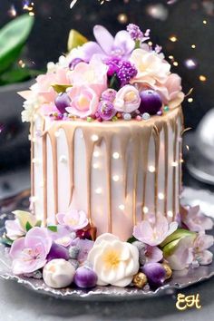 a cake decorated with flowers and icing on top of a silver platter next to confetti sprinkles