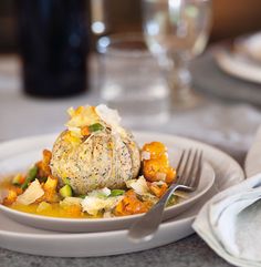 a white plate topped with food on top of a table next to a fork and knife