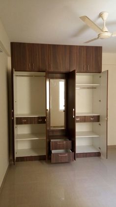 an empty room with wooden closets and white walls