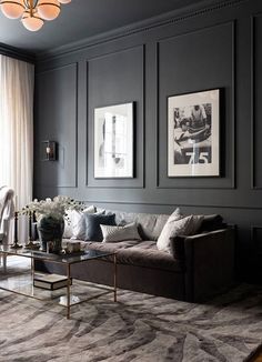 a living room filled with furniture and pictures on the wall above it's coffee table