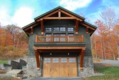 a large house with two garages on the front and second story, surrounded by fall foliage