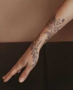 a person's arm with tattoos on it and flowers in the middle of their arm