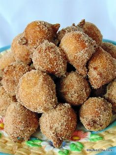 some sugared donuts are on a blue and yellow plate