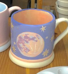 two mugs sitting on top of a wooden table