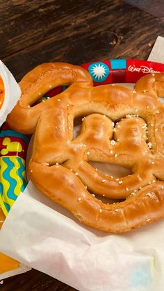 two pretzels sitting on top of paper next to some candy and other items