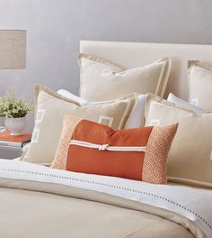 a bed with orange and white pillows on it