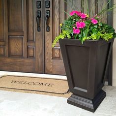 a large planter with flowers in front of a door